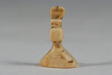 A miniature ancient Inuit game piece carved from walrus ivory