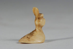 A miniature ancient Inuit game piece carved from walrus ivory