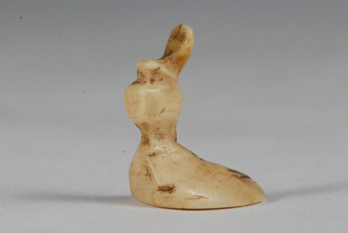 A miniature ancient Inuit game piece carved from walrus ivory